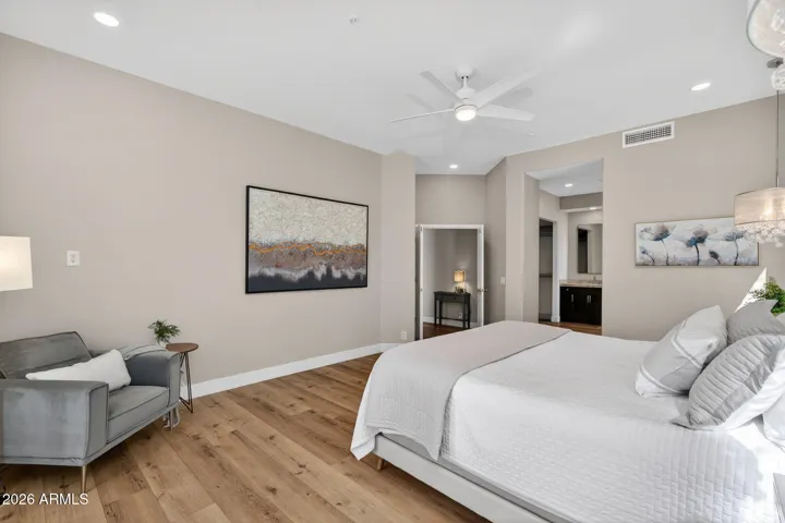 Generous Scottsdale primary bedroom with ample space for seating, low maintenance flooring, and open access to the ensuite bath, blending comfort and functionality.