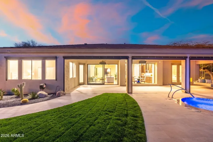 Beautiful Scottsdale backyard with lush green lawn, covered patio, and direct access to the pool and spa, offering ideal outdoor living and entertaining space.