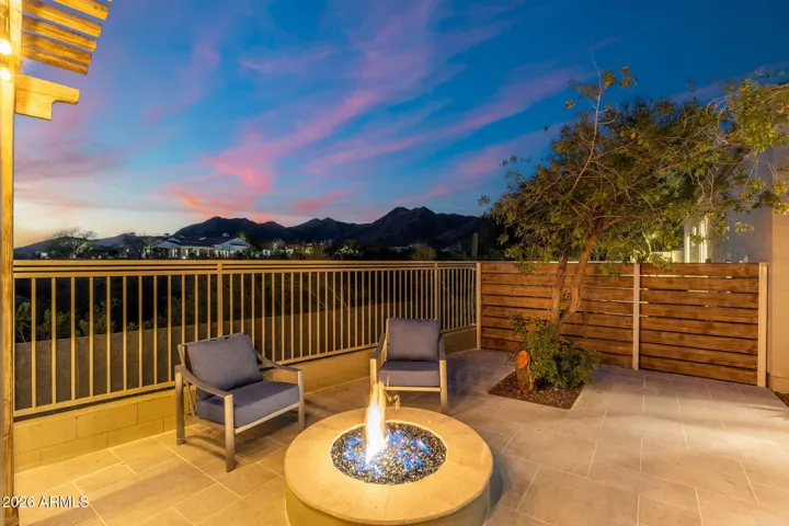 Cozy Scottsdale patio featuring a modern fire pit, seating area, and unobstructed mountain views—perfect for relaxing under the desert night sky.