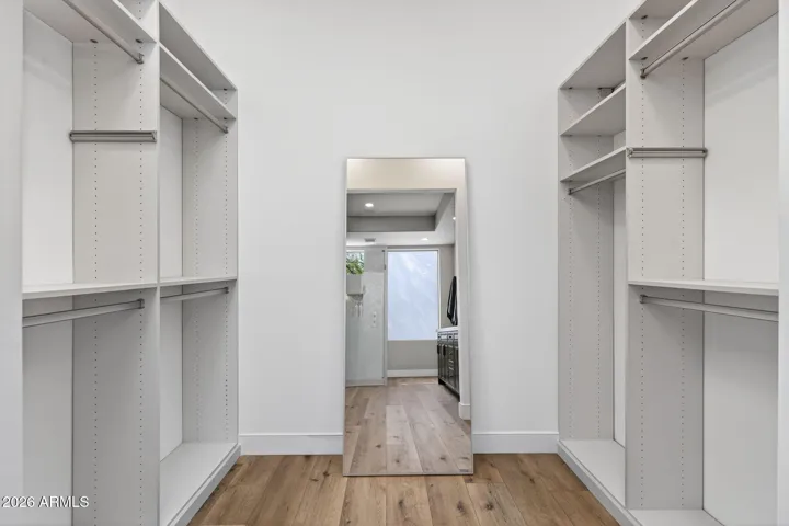 Organized Scottsdale walk-in closet with built-in shelving and hanging space, providing ample storage and efficient layout.