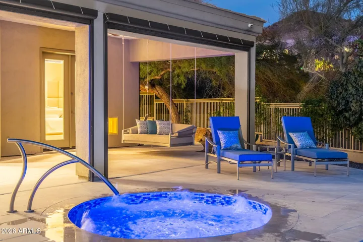 Relaxing spa with water features beside a shaded lounge area, highlighting Scottsdale outdoor living with modern design, comfortable seating, and private ambiance.