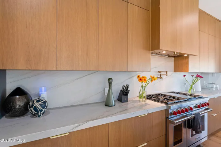 Beautiful kitchen detail showcasing custom cabinetry, quartz surfaces, and premium gas range. This Paradise Valley home offers a chef’s kitchen with modern upgrades and elegant design.