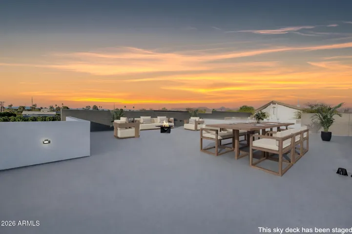 Elevated sky deck with panoramic sunset views and outdoor seating areas. This Paradise Valley home offers a rare rooftop retreat perfect for entertaining and enjoying scenic mountain vistas. The is virtually staged to show how expansive the deck is.