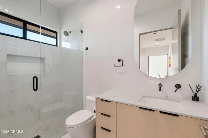 Contemporary bathroom with glass shower enclosure, modern vanity, and updated fixtures. This Paradise Valley home features stylish finishes and functional design.