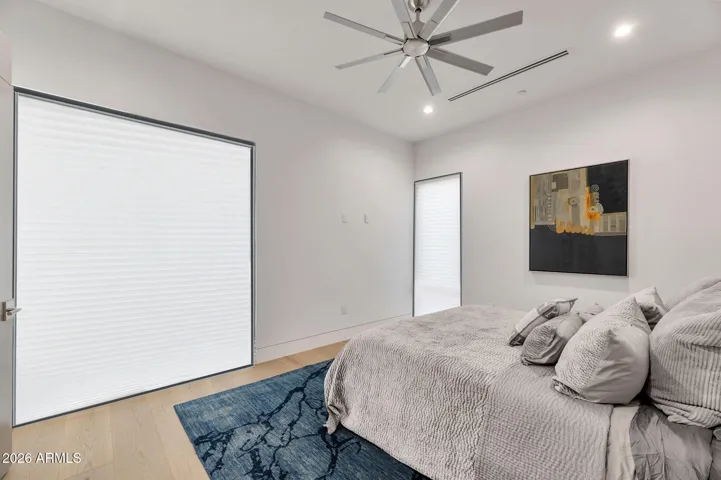 Inviting guest bedroom with plush carpeting, contemporary design, and abundant natural light. This Paradise Valley home showcases well-appointed secondary bedrooms.
