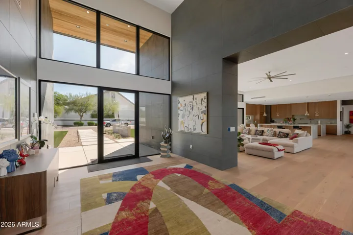 Dramatic front entrance with floor-to-ceiling glass doors, high ceilings, and modern finishes. This Paradise Valley estate creates an impressive and welcoming first impression.