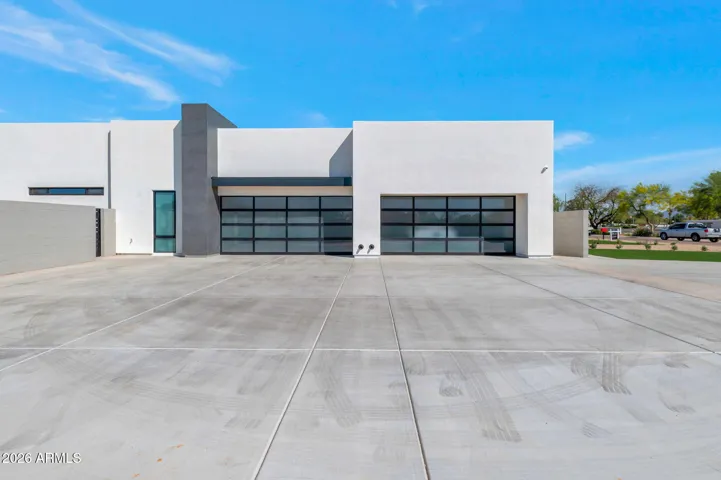 Contemporary garage with sleek glass doors and clean lines. This Paradise Valley home features modern design and generous storage space.