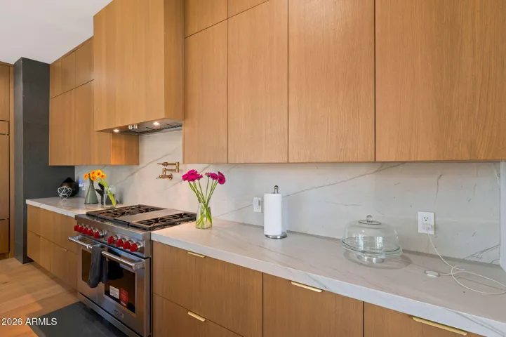 Sleek kitchen cabinetry paired with quartz countertops and designer backsplash creates a clean, modern look. This Paradise Valley home features high-end finishes, energy-efficient appliances, and thoughtful updates throughout.