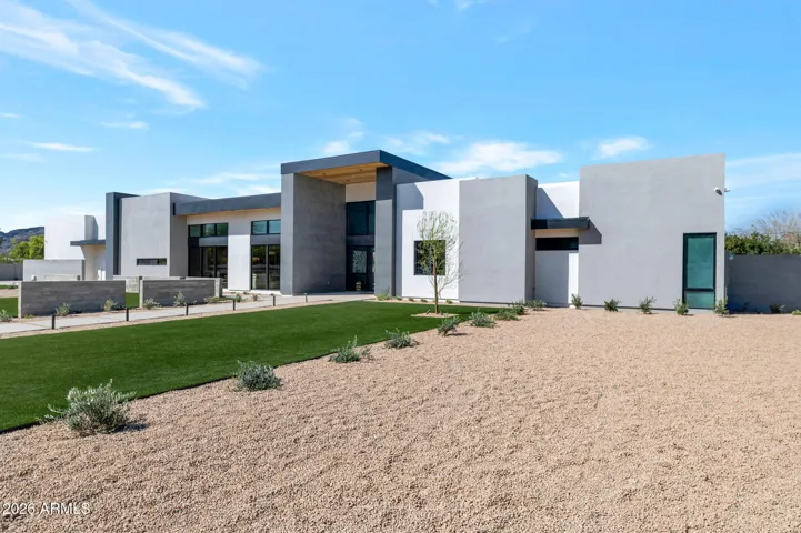 Southwest angle of the home highlighting sleek lines, flat roof design, and expansive windows. This Paradise Valley property blends modern architecture with desert landscaping for a refined exterior.