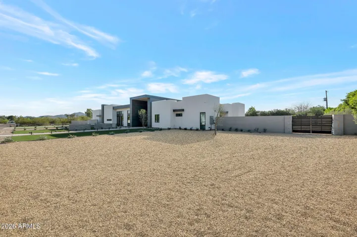 North-facing exterior view featuring clean stucco finishes, geometric design, and gated entry. This Paradise Valley home offers privacy, security, and contemporary curb appeal.
