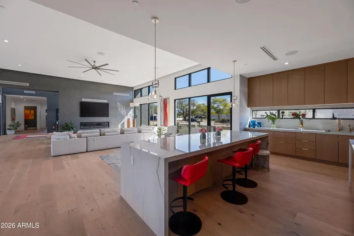 Sunlit kitchen with large windows, custom cabinetry, and expansive counter space. This Paradise Valley home offers a bright and open cooking environment.