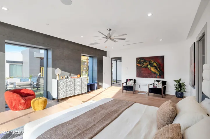 Spacious primary bedroom with large windows, natural light, and modern design. This Paradise Valley home features clean lines, wood flooring, and seamless indoor-outdoor flow.