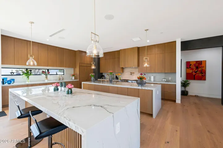 Chef-inspired kitchen featuring dual islands, quartz countertops, custom cabinetry, and high-end appliances. This Paradise Valley home is ideal for entertaining and everyday living.