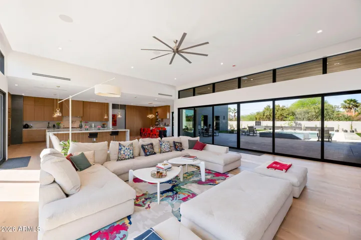 Expansive open living area with direct views of the pool and patio through large sliding glass doors. This Paradise Valley home offers a bright, airy layout perfect for entertaining.