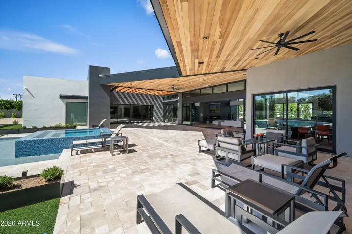 The generous covered patio off of the living room and primary suite is another entertainment gathering space