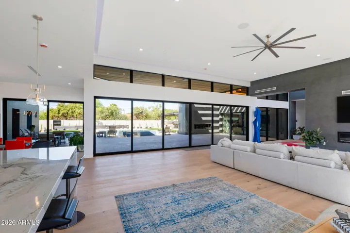Spacious open-concept layout connecting living room, kitchen, and dining areas with high ceilings and abundant natural light. This Paradise Valley home highlights modern architecture and seamless flow.