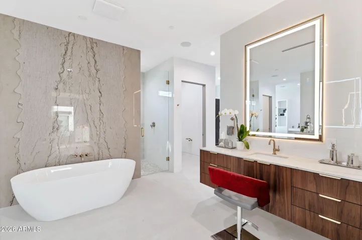 Luxurious primary bathroom featuring a freestanding soaking tub, dual vanity, quartz countertops, and designer lighting. This Paradise Valley home offers a spa-like retreat with modern finishes and high-end upgrades.