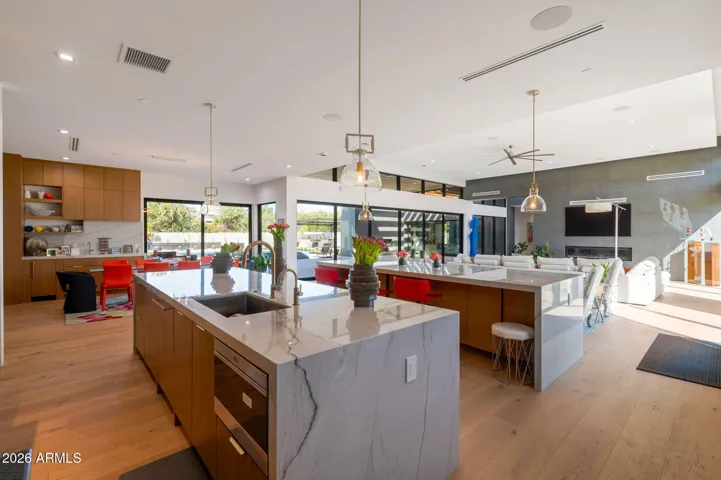 Open kitchen with two oversized islands, sleek cabinetry, and designer lighting. This Paradise Valley home offers exceptional space for cooking and gathering.