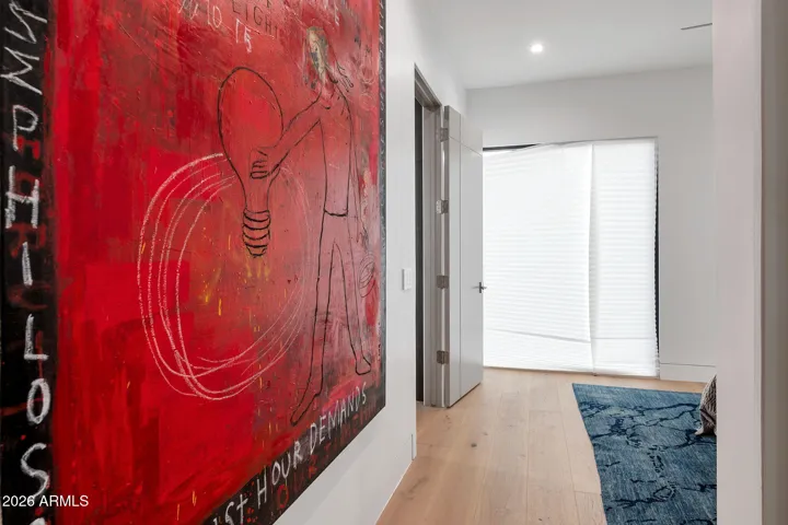 Bright hallway with wood flooring, modern lighting, and statement artwork. This Paradise Valley home showcases clean lines and contemporary design throughout.