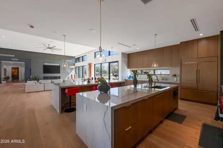 Spacious kitchen with dual islands, modern lighting, and high-end appliances. This Paradise Valley home highlights clean lines and a sophisticated layout.
