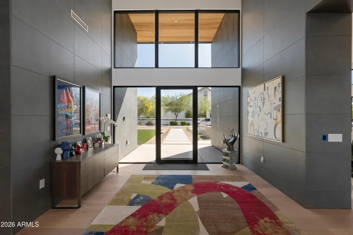 Striking front entrance with soaring ceilings, custom glass doors, and sleek modern finishes. This Paradise Valley estate creates a dramatic first impression with architectural design and natural light.