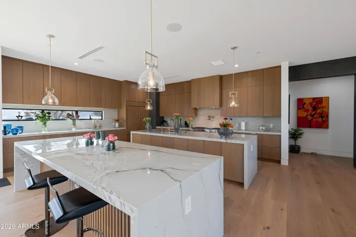 Gourmet kitchen with oversized island, quartz countertops, custom cabinetry, and high-end appliances. This Paradise Valley home is designed for entertaining and everyday living.