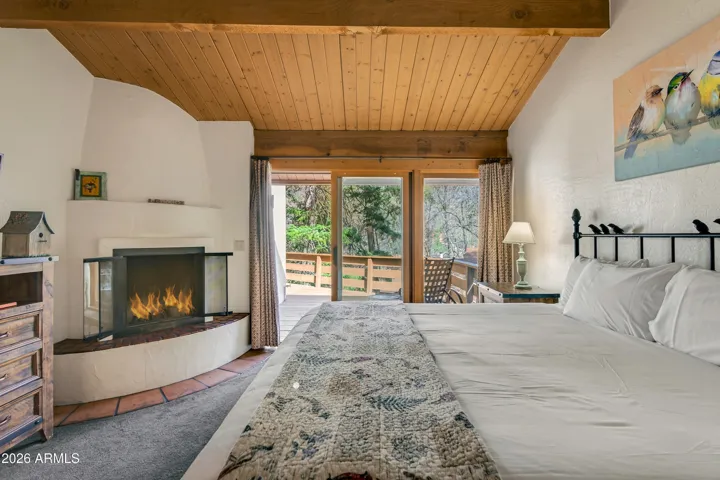 Primary Suite with walls of windows and a wood burning fireplace