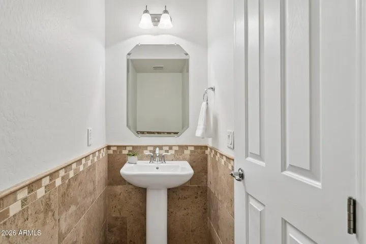 First floor half bath with pedestal sink and tile wainscoting that adds character