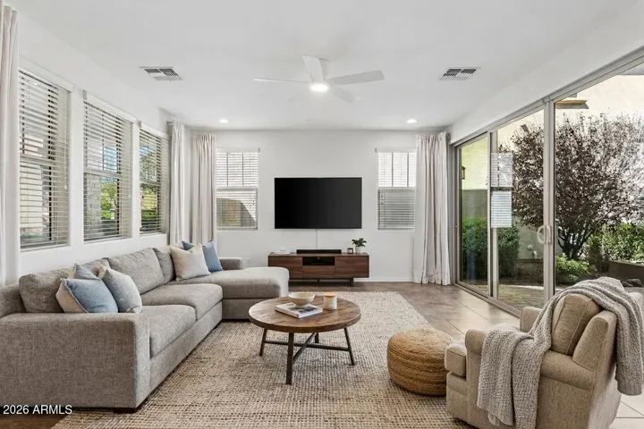The great room is filled with natural light from five windows and oversized 4-panel sliding doors (virtually staged)