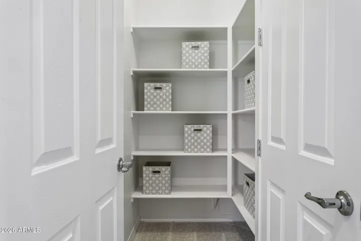 Hall walk-in closet with shelves on the second floor