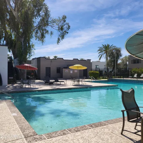 Beautiful community pool with seating, umbrellas and club house just north of home.