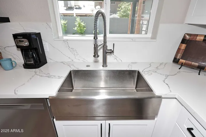 Stainless steel framer sink overlooking backyard