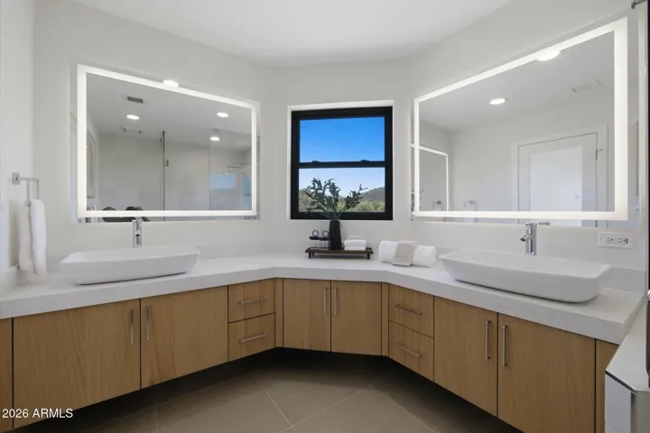 Contemporary guest bathroom with stylish dual vanity, ample counter space, and chic illuminated mirrors.