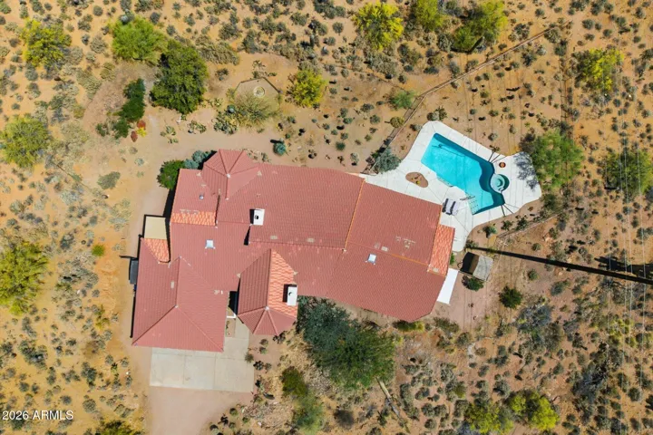 Overhead view highlighting the home's design and integrated pool within the natural desert landscape.
