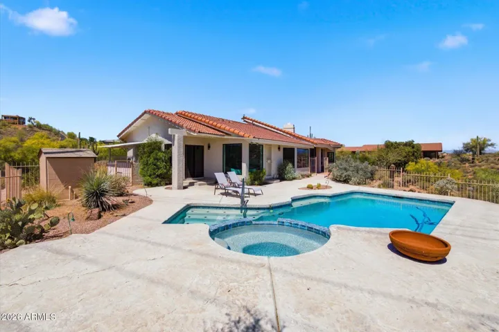 The home's rear exterior showcases a sparkling pool and spa, creating a private oasis amidst the beautiful desert setting.