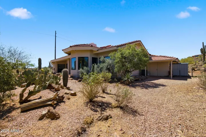 Charming home exterior, harmoniously blending with the surrounding desert flora.