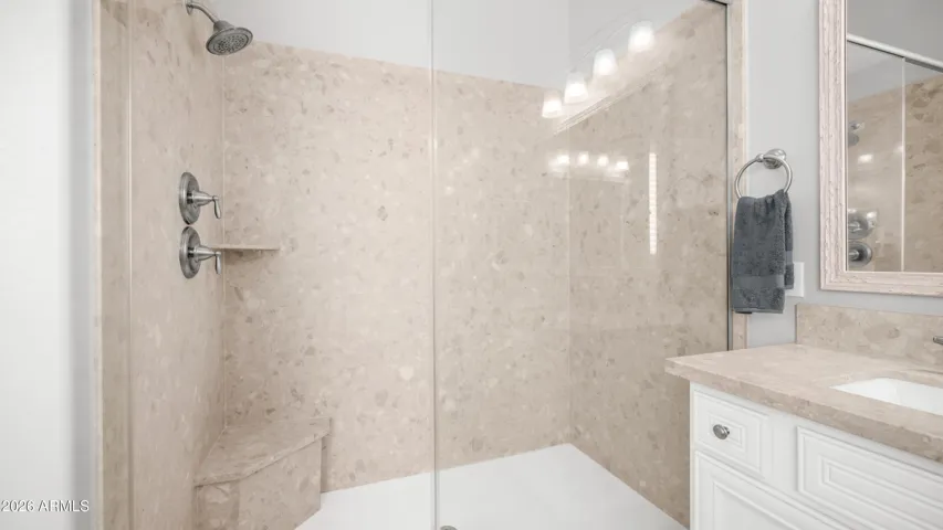 A Spacious Walk-In Shower with Built In Bench and Refined Finishes