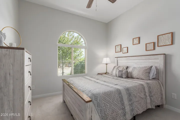 Peaceful guest retreat with high ceilings, arched window, and designer finishes.