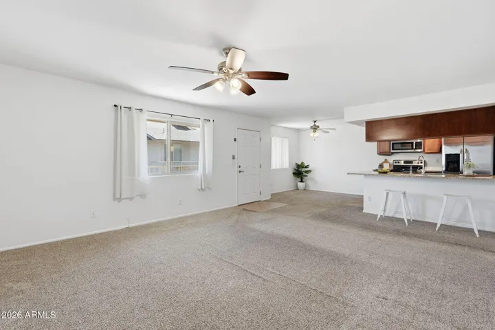 Bright and open living room in Scottsdale condo featuring a spacious layout ideal for relaxing or entertaining with seamless flow to the dining and kitchen areas.