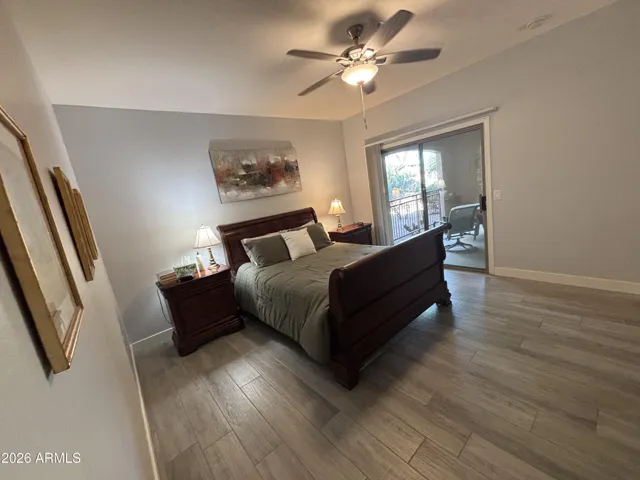 Primary Bedroom has ensuite bathroom, ceiling fan and sliding glass door to covered West patio