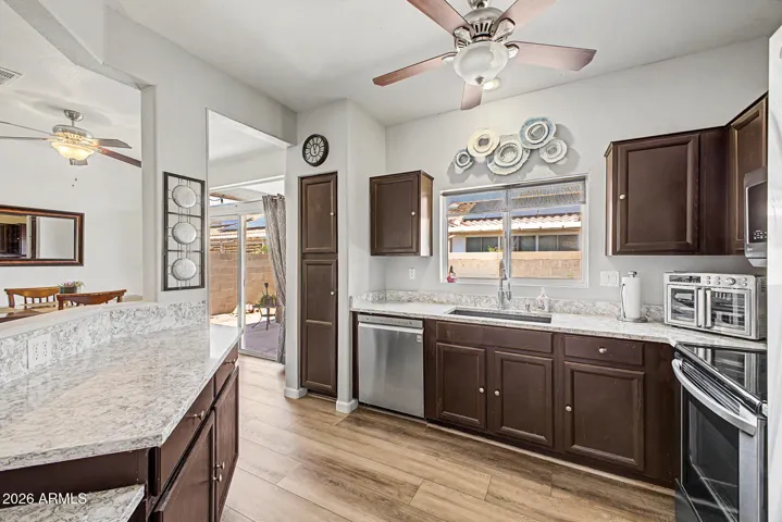 Charming, functional kitchen with stainless steel appliances, granite countertops & breakfast bar.
