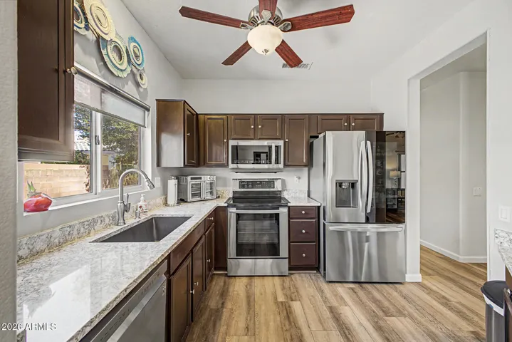 Charming, functional kitchen with stainless steel appliances, granite countertops & breakfast bar.