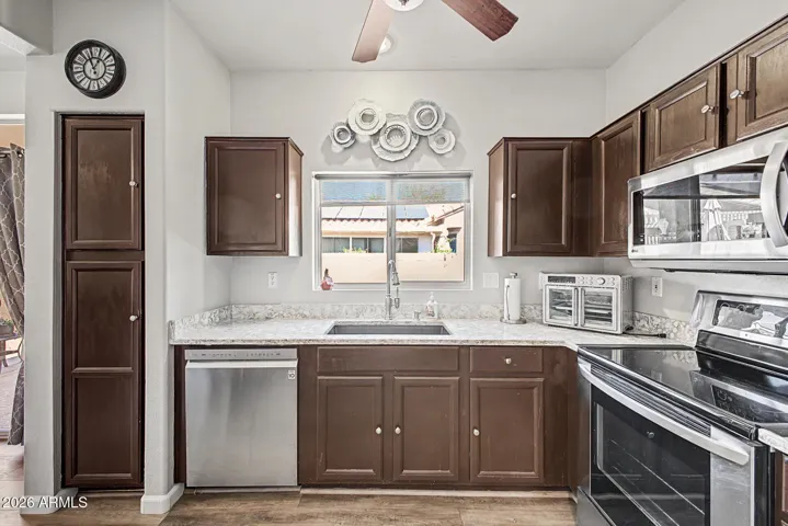 Charming, functional kitchen with stainless steel appliances, granite countertops & breakfast bar.