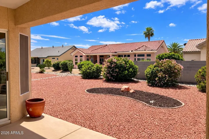 Private, low-maintenance backyard featuring desert landscaping, mature plantings, and covered patio — perfect for relaxing or entertaining.
