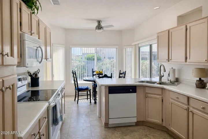 Bright kitchen with abundant cabinetry, breakfast nook, and natural light overlooking backyard patio.