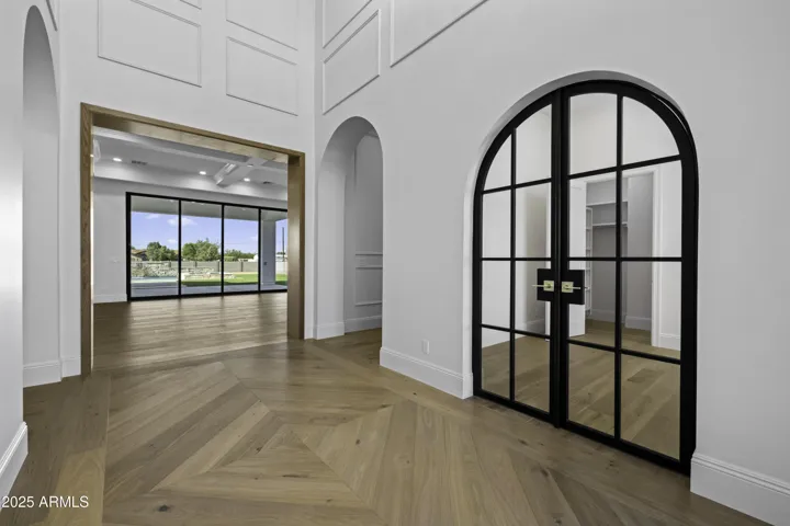 The entry to the office begins with a custom made round iron and glass door. This is the ideal space for any home office, music room or library. This room has a walk in closet as well.