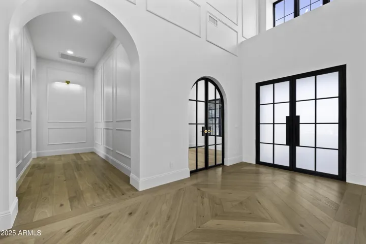 The custom wood floors boast a beautiful design that reflects the tongue and groove vaulted ceiling above it.