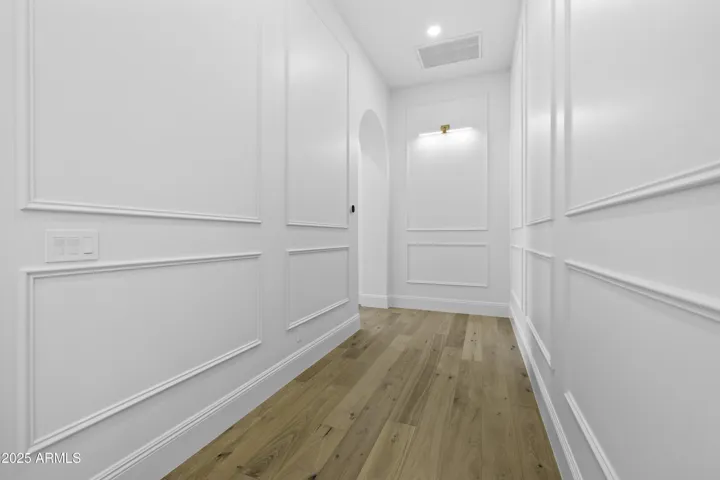 The hallway to the Primary Suite is finished with detailed molding that adds a sophisticated and timeless touch.