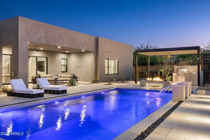 This incredible yard features a saltwater pool with advanced cleaning system, custom steel shade structure with custom built in kitchen, putting green, outdoor shower, suspended firepit, expansive covered patio, upgraded decking and gorgeous mountain views.