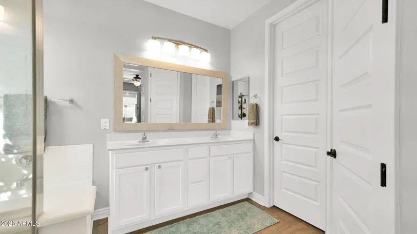 Primary bathroom with double vanity and walk-in closet, offering a calm, well-designed space to start and end the day.